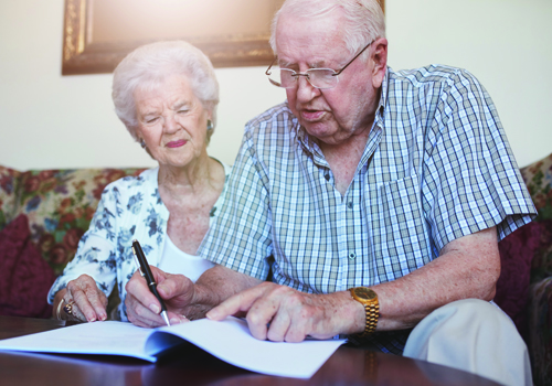 older couple signing papers